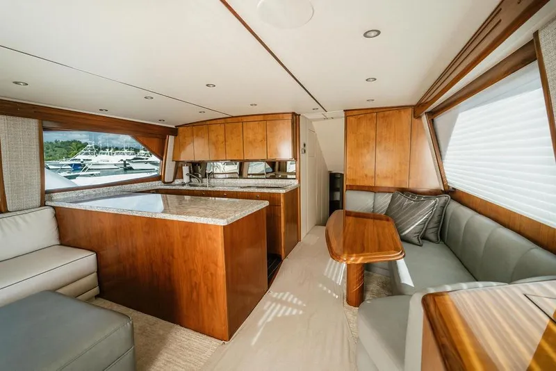 Slide: The Image of Luxurious interior of 2021 Viking 58 Convertible yacht with elegant wood finishes and seating. - 62