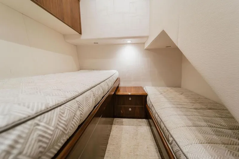 Slide: The Image of Interior of 2021 Viking 58 Convertible yacht with twin beds and wooden cabinetry. - 70