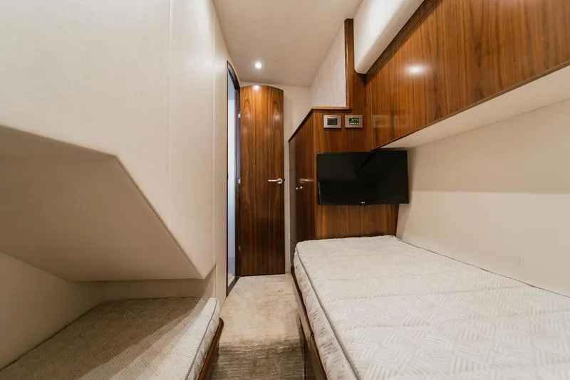 Slide: The Image of Interior of 2021 Viking 58 Convertible yacht with twin beds and wooden accents. - 71