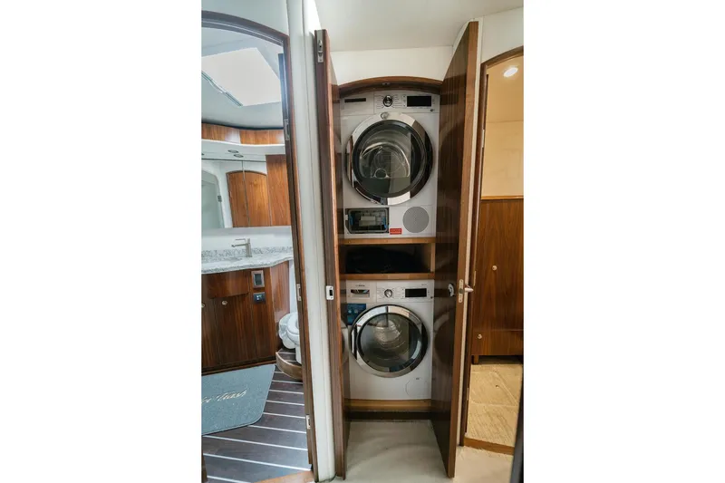 Slide: The Image of Laundry area with stacked washer and dryer in 2021 Viking 58 Convertible yacht. - 72