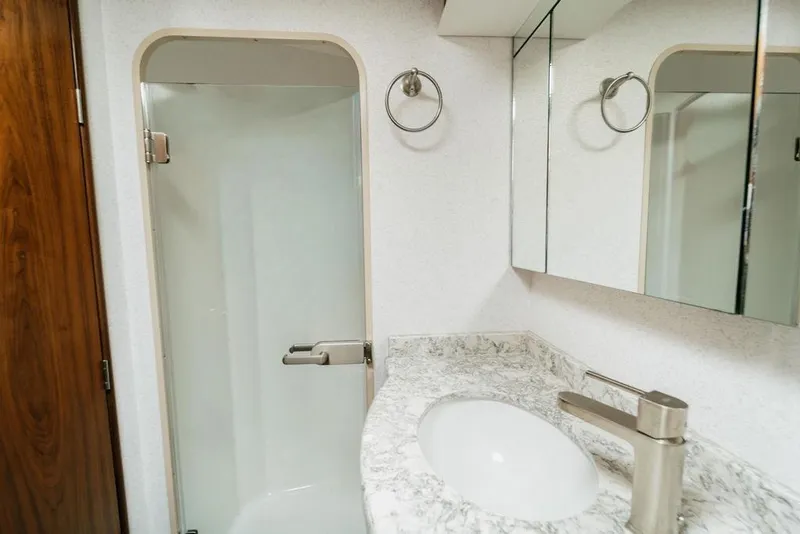 Slide: The Image of Modern bathroom in 2021 Viking 58 Convertible yacht with marble countertop and glass shower. - 75