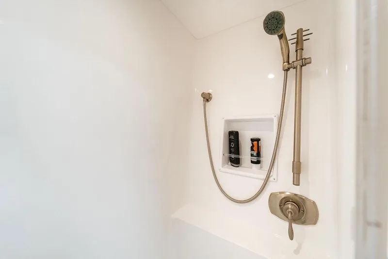 Slide: The Image of Shower area in 2021 Viking 58 Convertible yacht with handheld showerhead and toiletries. - 76