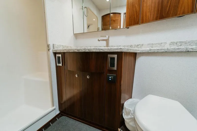 Slide: The Image of Luxurious bathroom in 2021 Viking 58 Convertible yacht with modern fixtures and wood cabinetry. - 79
