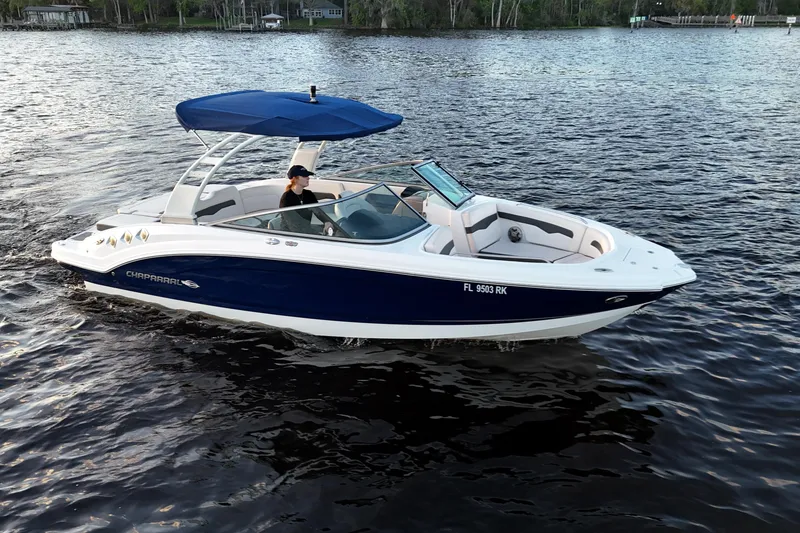 Slide: The Image of 2017 Chaparral 246 SSi boat cruising on a calm lake with blue canopy. - 8