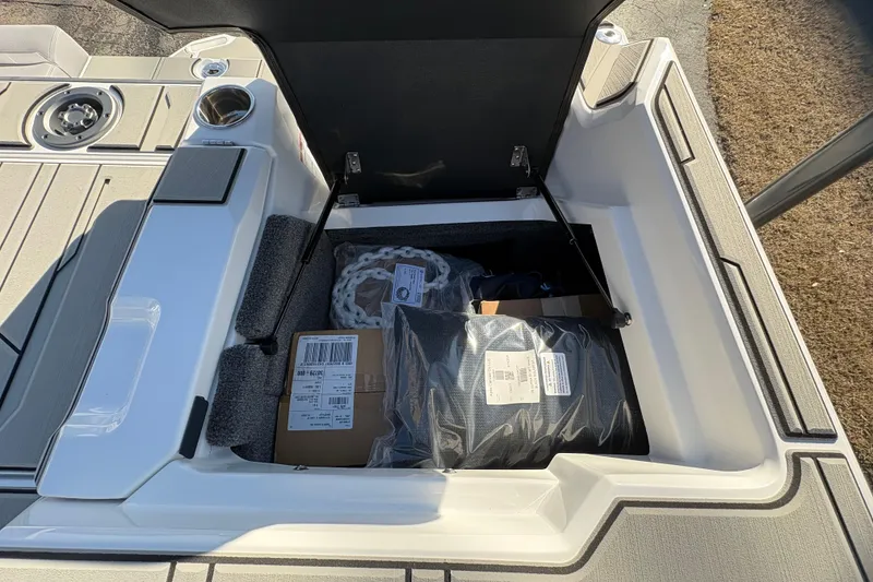 Slide: The Image of Storage compartment of 2026 Supra SL 450 boat, containing packaged items and a chain. - 16