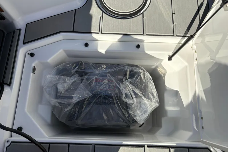 Slide: The Image of Storage compartment of 2026 Supra SL 450 boat, featuring a covered item inside. - 34