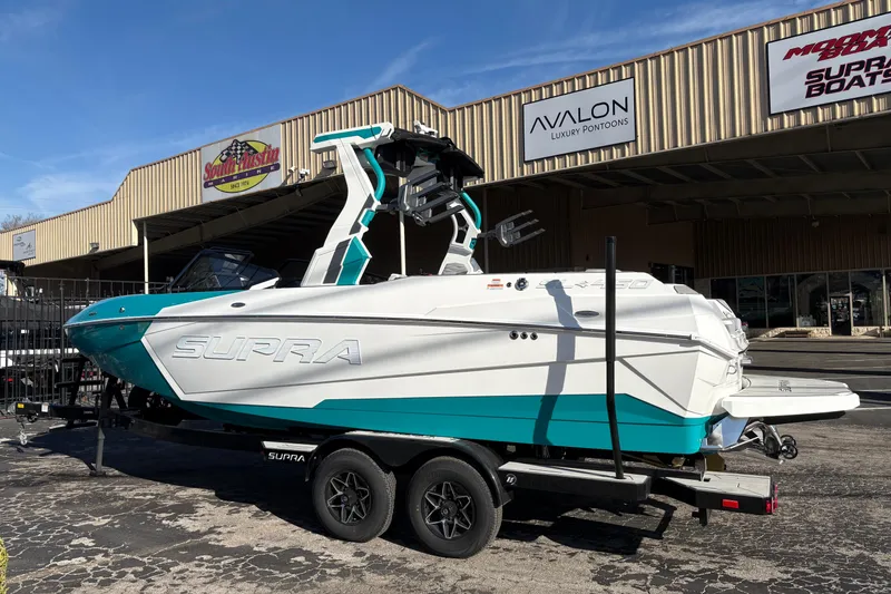 Slide: The Image of 2026 Supra SL 450 boat on trailer outside dealership, showcasing sleek design and vibrant colors. - 5
