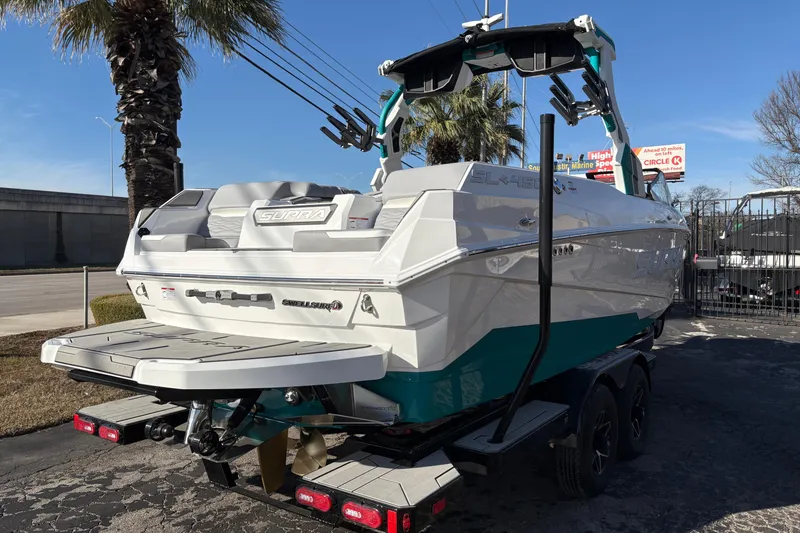 Slide: The Image of 2026 Supra SL 450 boat on trailer, parked outdoors near palm trees. - 8