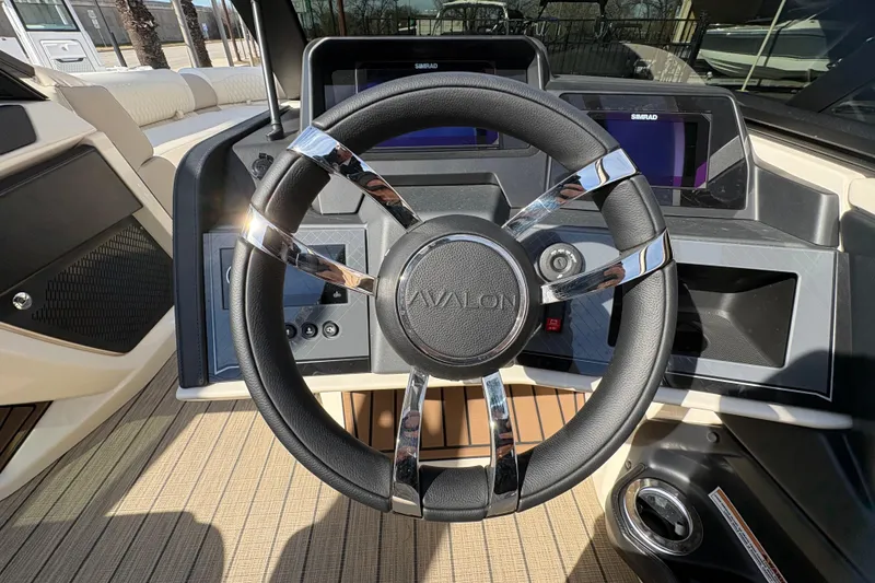 Slide: The Image of Steering wheel of 2026 Avalon Exalibur LTD 27 Elite Winshield boat, featuring modern dashboard design. - 28