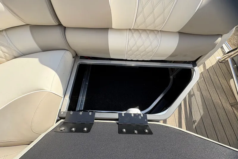 Slide: The Image of 2026 Avalon Exalibur LTD 27 Elite Winshield boat seat storage compartment open. - 33