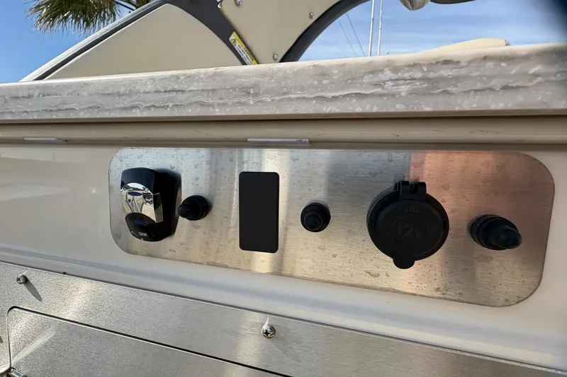 Slide: The Image of Control panel of 2026 Avalon Exalibur LTD 27 Elite Winshield boat with switches and 12V outlet. - 39