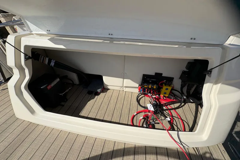 Slide: The Image of Open storage compartment of 2026 Avalon Exalibur LTD 27 Elite Winshield boat with wiring and equipment. - 44
