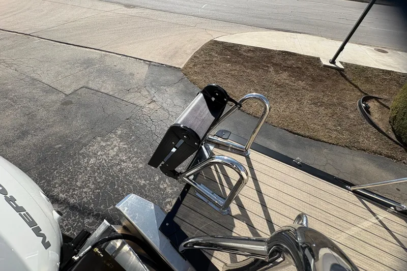 Slide: The Image of 2026 Avalon Exalibur LTD 27 Elite Winshield boat deck with chrome details and ladder. - 47