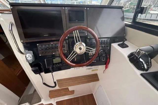 Slide: The Image of 2026 Cutwater C-288 Coupe helm with modern controls and wooden steering wheel. - 10