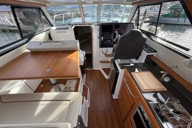 Slide: The Image of 2026 Cutwater C-288 Coupe interior with modern helm, dining area, and kitchenette. - 5