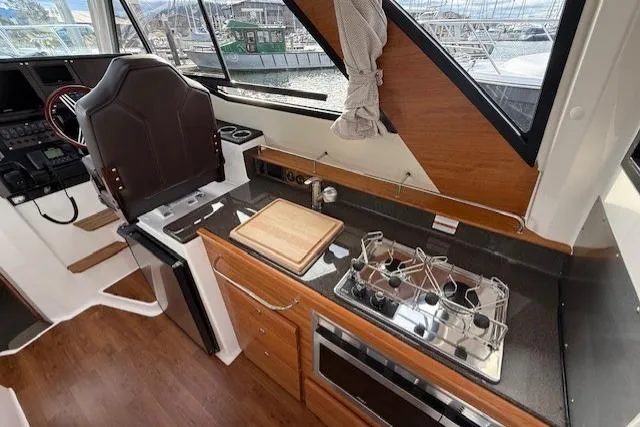 Slide: The Image of 2026 Cutwater C-288 Coupe interior with kitchen, stove, and captain's chair. - 6