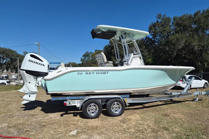 The Image of 2026 Key West 239 FS boat on trailer with Honda outboard motor, parked outdoors. - 0