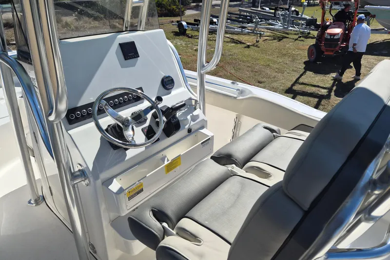 Slide: The Image of 2026 Key West 239 FS boat interior with steering wheel and cushioned seating. - 2