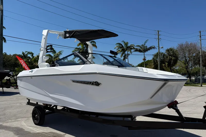 The Image of 2026 Nautique Super Air Nautique G21 boat on trailer, sunny day. - 12