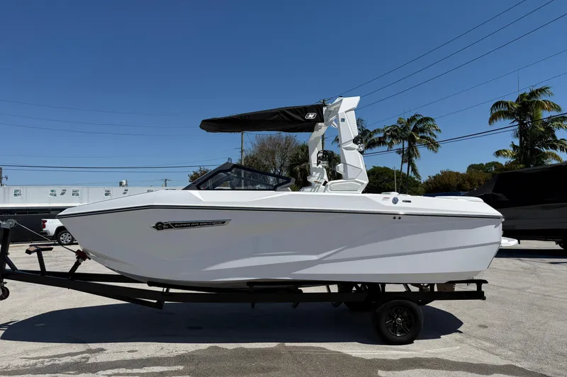Slide: The Image of 2026 Nautique Super Air Nautique G21 boat on trailer, sunny day, palm trees in background. - 18