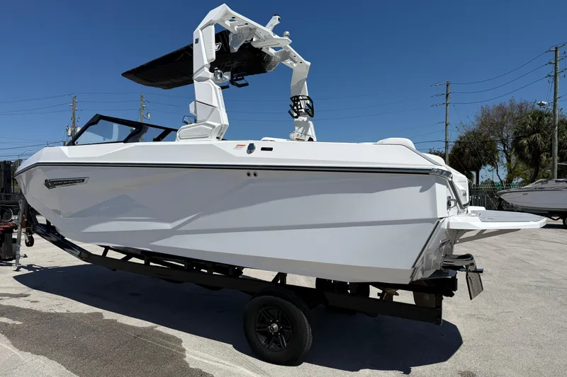 Slide: The Image of 2026 Nautique Super Air Nautique G21 boat on trailer under clear blue sky. - 21