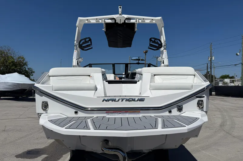 Slide: The Image of 2026 Nautique Super Air Nautique G21 boat, rear view, white exterior, sunny day. - 22