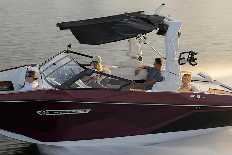 Slide: The Image of 2026 Nautique Super Air Nautique G21 boat cruising with passengers on a calm lake. - 9