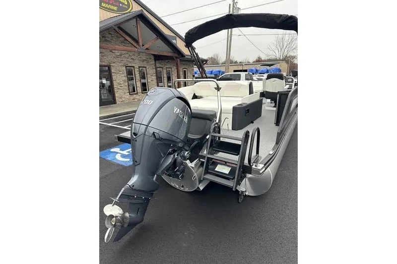Slide: The Image of 2026 EVOTTTI 523CS pontoon boat with Yamaha outboard motor, parked outside a marine store. - 8