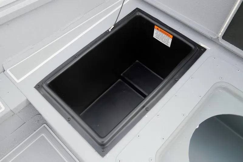 Slide: The Image of Storage compartment in 2026 G3 Bay 17 boat, featuring a black interior and warning label. - 13
