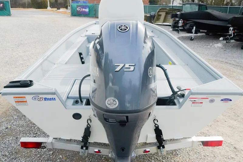 Slide: The Image of 2026 G3 Bay 17 boat with Yamaha 75 engine, parked on gravel. - 2