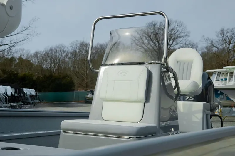 Slide: The Image of 2026 G3 Bay 17 boat interior with white seating and console, parked outdoors. - 6