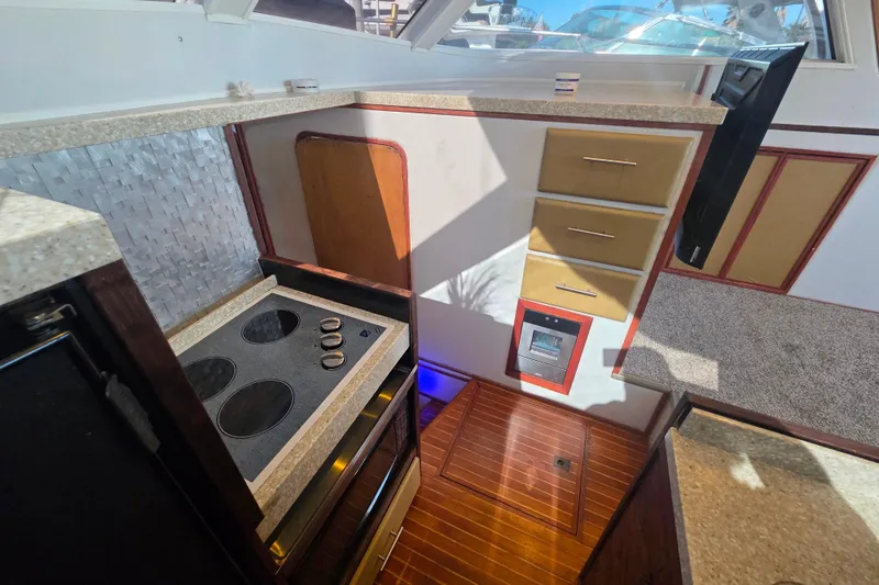 Slide: The Image of Interior of 1990 Novatec 44 Aft Cockpit Motor Yacht kitchen with stove and cabinetry. - 16