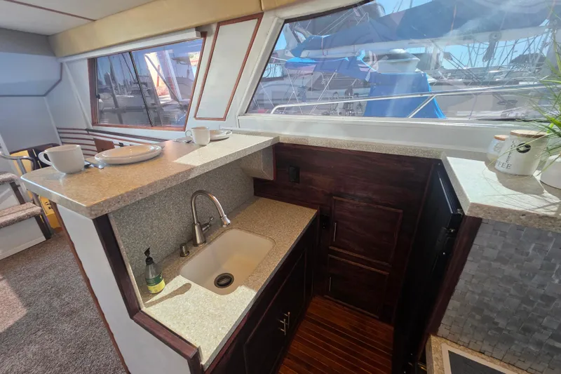Slide: The Image of 1990 Novatec 44 Aft Cockpit Motor Yacht interior with kitchenette and window view. - 17