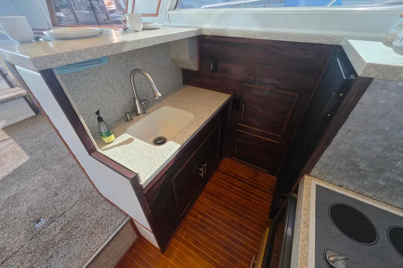 Slide: The Image of 1990 Novatec 44 Aft Cockpit Motor Yacht kitchen with sink, countertop, and wooden flooring. - 18