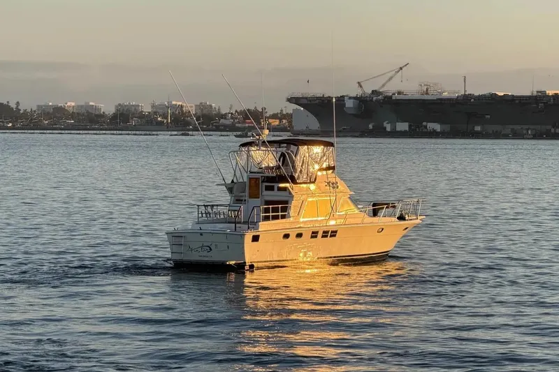 Slide: The Image of Novatec 1988 yacht on calm water at sunset, with cityscape and shipyard in the background. - 2