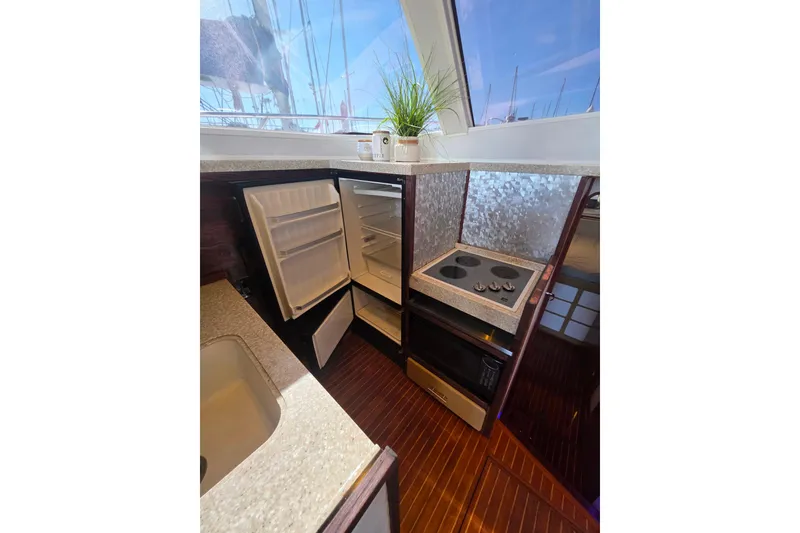 Slide: The Image of Novatec 44 Aft Cockpit Motor Yacht 1990 kitchen with open fridge, stove, and microwave. - 20