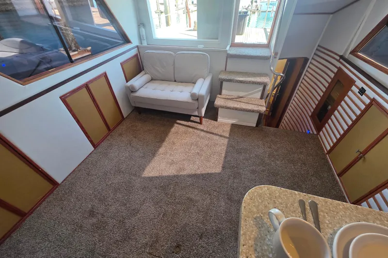 Slide: The Image of Interior of 1990 Novatec 44 Aft Cockpit Motor Yacht with cozy seating and carpeted flooring. - 24