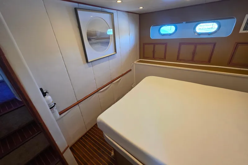 Slide: The Image of Cozy bedroom in 1990 Novatec 44 Aft Cockpit Motor Yacht with porthole windows and framed artwork. - 27