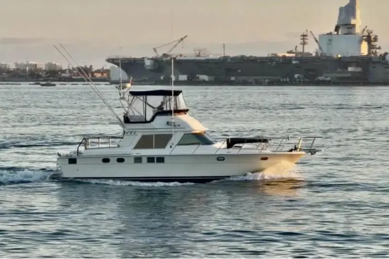 Slide: The Image of 1988 Novatec boat cruising on water with a large ship in the background. - 3
