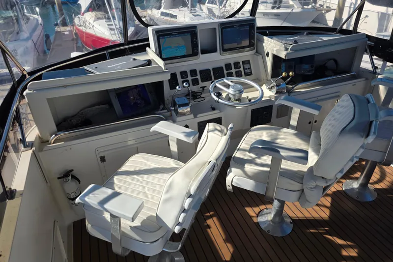 Slide: The Image of Cockpit of 1990 Novatec 44 Aft Cockpit Motor Yacht with dual white captain chairs. - 46