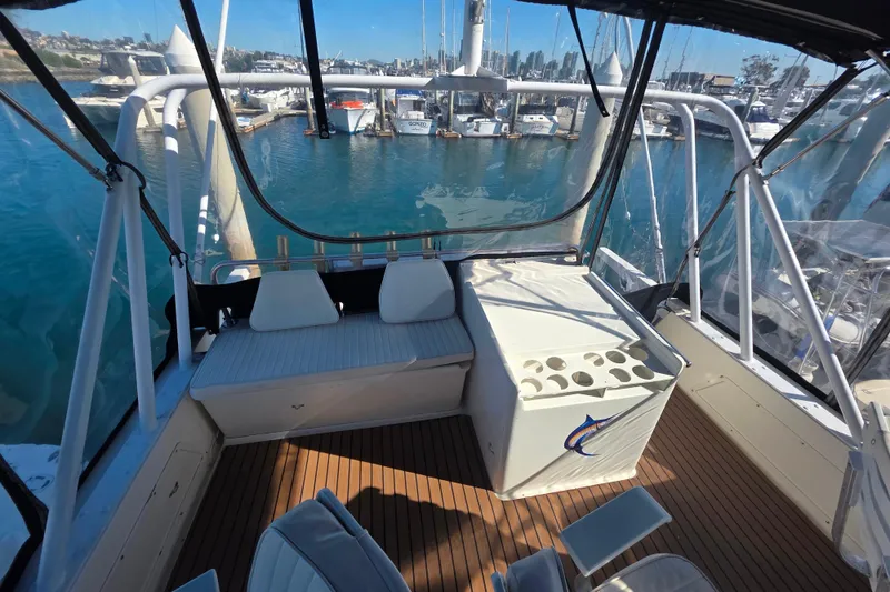 Slide: The Image of 1990 Novatec 44 Aft Cockpit Motor Yacht interior with marina view, featuring seating and storage. - 47