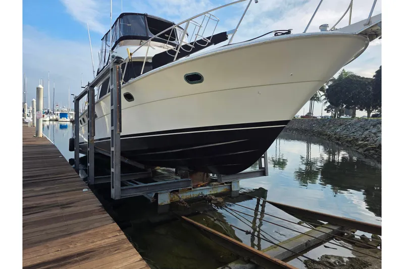 Slide: The Image of 1988 Novatec boat on lift at marina, calm water, clear sky. - 5