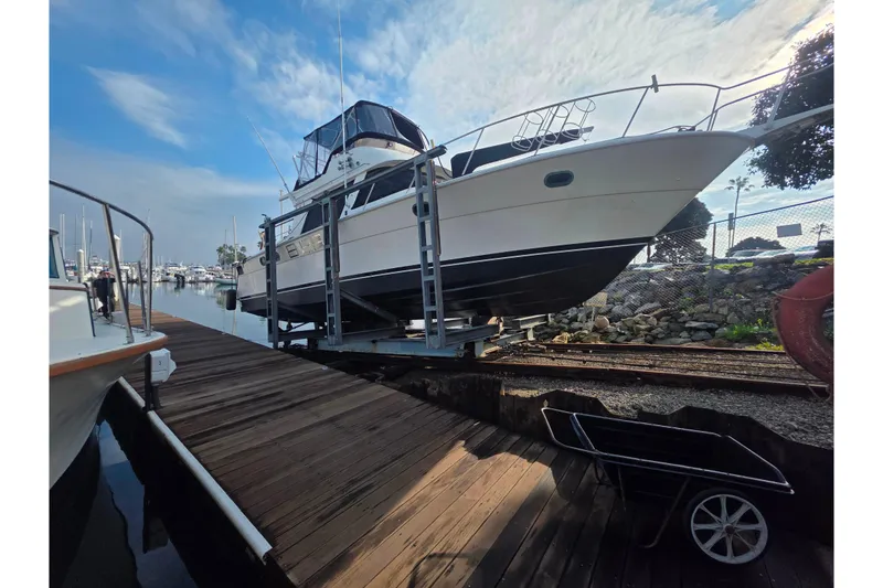 Slide: The Image of Novatec 1988 boat on dock, marina background, clear sky, wooden walkway. - 6