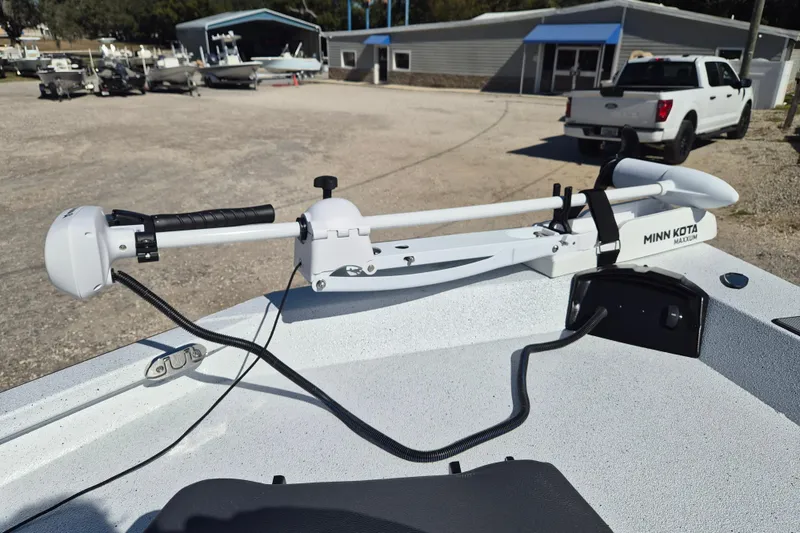 Slide: The Image of 2026 Xpress H20B Bay boat with Minn Kota Maxxum trolling motor in a marina setting. - 10