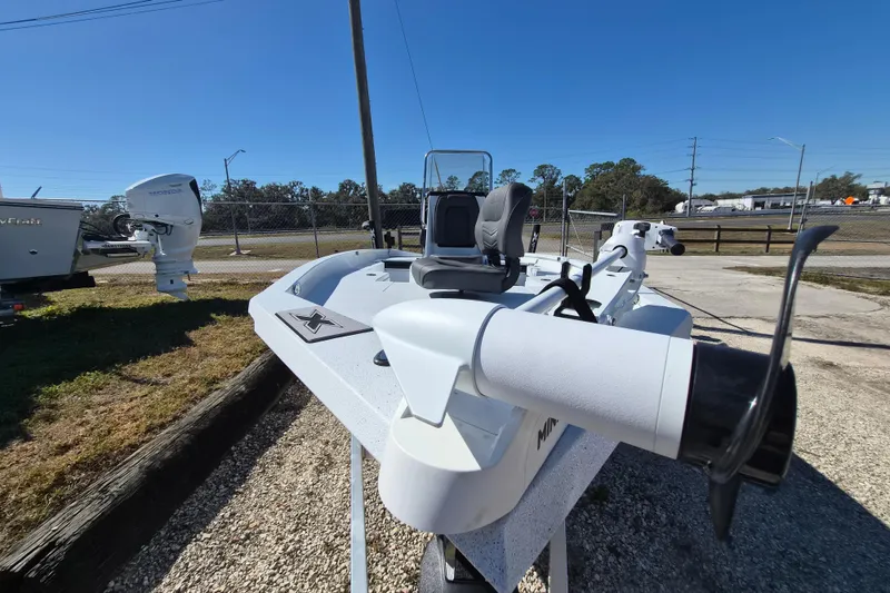 Slide: The Image of 2026 Xpress H20B Bay boat with Honda outboard motor, parked outdoors. - 11