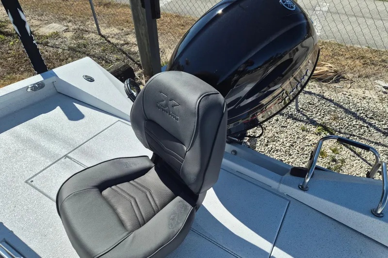 Slide: The Image of 2026 Xpress H20B Bay boat seat and motor, outdoor setting. - 6