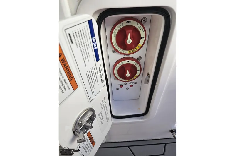 Slide: The Image of Control panel with red switches and warning labels on a 2025 Concept 27' CC boat. - 114