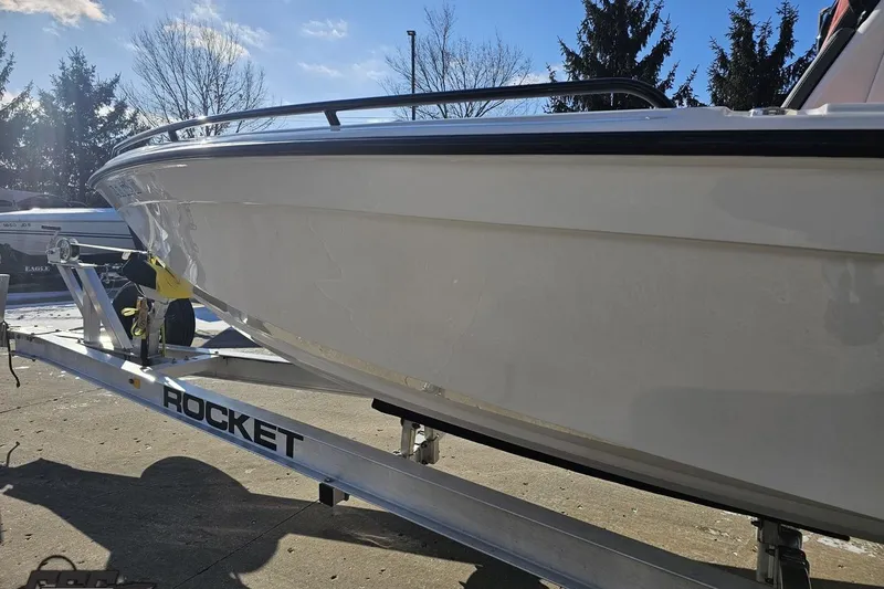 Slide: The Image of 2025 Concept 27' CC boat on Rocket trailer, parked outdoors under clear sky. - 24