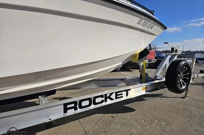 Slide: The Image of 2025 Concept 27' CC boat on Rocket trailer, parked outdoors on a sunny day. - 9
