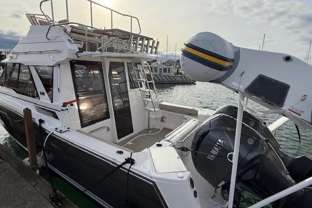 Slide: The Image of 2026 Cutwater C-288 CB boat docked at marina, featuring modern design and powerful outboard motor. - 2